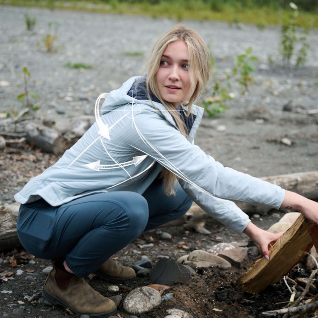 Woman wearing Aktivator® Jacket while walking through fall foliage.