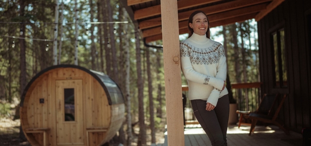 A woman outside on her truck wearing a Kühl Sofie™ Sweater.