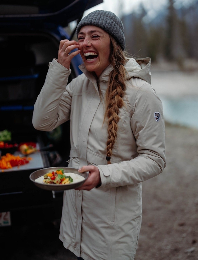 A girl wearing a raincoat and smiling into the camera.